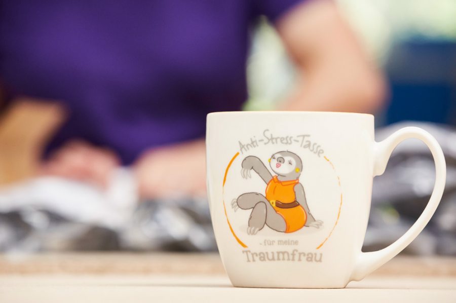 Großaufnahme einer Bürotasse mit der Aufschrift: „Anti-Stress-Tasse für meine Traumfrau“. Das Bild dazu zeigt eine attraktive, entspannte Maulwurfdame im gelben Kleid.